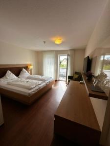 1 dormitorio con 1 cama grande y escritorio en Gästehaus GN8, en Rielasingen-Worblingen