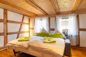 a bedroom with a bed with green pillows on it at Schwarzwaldstübchen nähe Europapark in Ettenheim