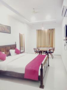 um quarto com uma cama grande e uma mesa em THE HAMIRGARH PALACE em Rājsamand