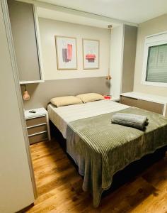 - une chambre avec un grand lit et une fenêtre dans l'établissement Apartamento Acqua, 102 A, com vaga de garagem, à Pelotas