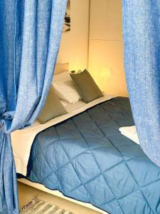 un letto con tende blu in una stanza di Giardino al mare a Rimini
