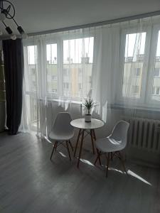 un tavolo con sedie in una stanza con finestre di Mieszkanie w centrum Nowej Soli a Nowa Sól