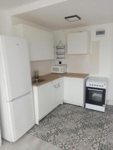una cucina con armadietti bianchi e frigorifero bianco di Mieszkanie w centrum Nowej Soli a Nowa Sól