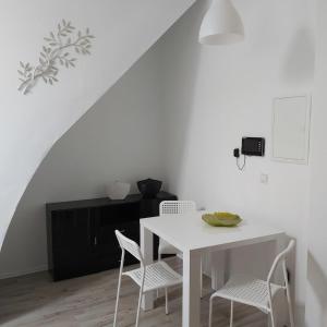 a white dining room with a white table and chairs at Megena in Mayen