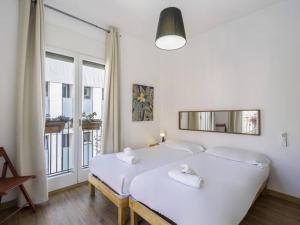 a bedroom with two white beds and a window at Heaven With a Garden at Las Ramblas in Barcelona