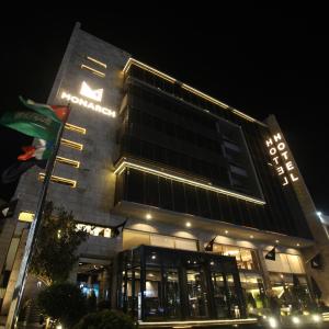 un bâtiment avec un panneau la nuit dans l'établissement Monarch Hotel Amman, à Amman