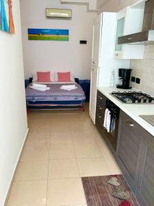 uma cozinha com uma cama no canto de um quarto em Giardino al mare em Rimini