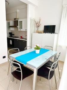 a dining room with a blue table and chairs at Giardino al mare in Rimini