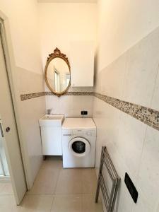 uma casa de banho com uma máquina de lavar roupa e um espelho. em Giardino al mare em Rimini