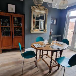 comedor con mesa, sillas y espejo en Inviting 2-Bed Character House Stamford, en Lincolnshire