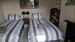 two beds sitting next to each other in a bedroom at Inviting 2-Bed Character House Stamford in Lincolnshire