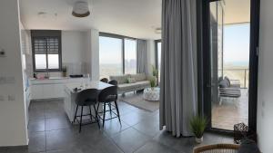 uma cozinha e sala de estar com mesa e cadeiras em דירת פאר על הים VIP apartment near the beach em H̱adera