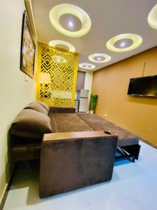 a room with a bed and a couch and a television at Bahria Town Lahore - NEXT INN Two Bedroom condo with free parking 203 in Lahore