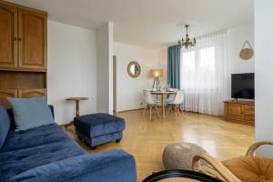 グディニャにある20 Apart - Mieszkanie dla 4 osóbのリビングルーム(青いソファ、テーブル付)