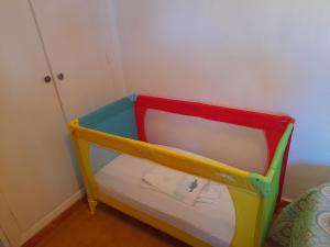 ein farbenfrohes Kinderbett in einer Ecke eines Zimmers in der Unterkunft Apartamento cerca del mar in Matalascañas