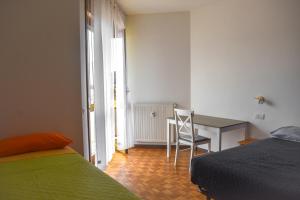 a bedroom with a desk and a bed and a chair at Ciceri Properties Monte Zeda in Verbania