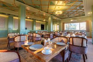 a dining room with wooden tables and chairs at Mountoria Retreat Bhimtal- by Leisure Hotels Group in Bhīm Tāl +9 photos