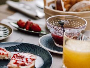 uma mesa com pratos de comida e um copo de sumo de laranja em Pension Rudolph em Gaschurn