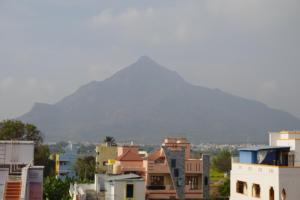 a view of a city with a mountain in the background at Wisma Gokilambal Residency in Tiruvannāmalai