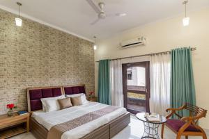 - une chambre avec un lit et un mur en briques dans l'établissement StayVista at Divine with River View & Library, à Rishikesh