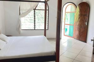 1 dormitorio con cama y ventana abierta en Mombasa at your doorstep! en Mombasa