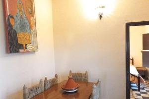 uma sala de jantar com uma mesa e um quadro na parede em Riad Elaissi em Tarudante