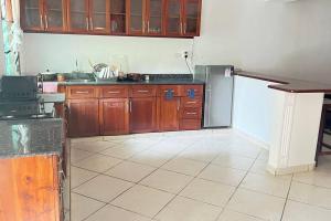 cocina con armarios de madera y nevera en Mombasa at your doorstep! en Mombasa