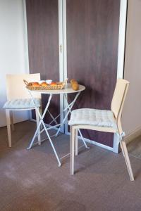 una mesa con una silla y una mesa con comida. en Le Sorbier By ApiRent #Wifi #Climatisation #Lumineux, en Cannes
