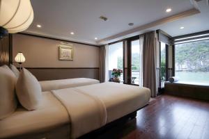 1 dormitorio con 2 camas y ventana grande en Lotus Luxury Cruise, en Ha Long