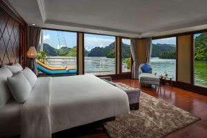 a bedroom with a large bed and a large window at Lotus Luxury Cruise in Ha Long