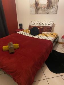 1 dormitorio con 1 cama con edredón rojo en Chambre dans maison proche Disneyland Paris, en Brie-Comte-Robert