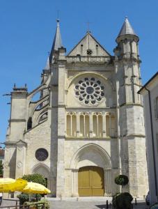 una vieja iglesia con una puerta amarilla y un edificio en Chambre dans maison proche Disneyland Paris, en Brie-Comte-Robert