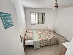 a small bedroom with a bed and a window at Hostal Cisne in San Antonio