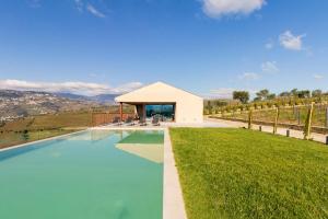 a swimming pool in front of a building at Luxury Vineyard Home with Infinity Pool in Douro Valley in Santa Marta de Penaguião