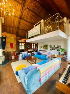 a living room with a blue couch and a piano at Tin tabernacle perfect for group getaways in Chale