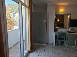 Zimmer mit einer Küche und einem großen Fenster in der Unterkunft Tonoz Beach Hotel in Oludeniz