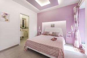 1 dormitorio con cama y pared púrpura en Le Rondinelle Rooms, en Procida