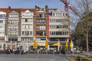 een groep gebouwen met gele paraplu's in een stad bij Appartement centrum 5 in Oostende