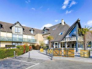 une grande maison avec une porte en face dans l'établissement Mercure Cabourg Hôtel & Spa, à Cabourg