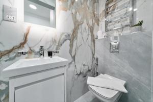 een witte badkamer met een wastafel en een toilet bij Baker Street Suite in Londen