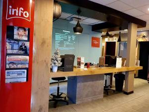 a counter in a store with a coca cola sign at Ibis Hôtel Sallanches in Sallanches