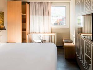 Un pat sau paturi într-o cameră la Ibis Hôtel Sallanches
