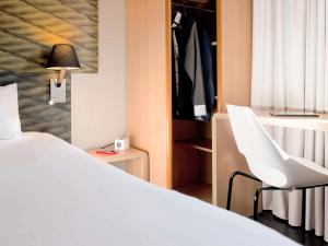 サランシュにあるIbis Hôtel Sallanchesのベッドルーム(白いベッド1台、白い椅子付)