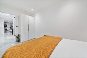 ein Schlafzimmer mit einem großen Bett und einer gelben Decke in der Unterkunft Baker Street Suite in London