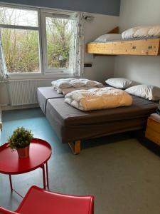 Habitación con 2 literas y mesa roja. en Danhostel Aalborg en Aalborg
