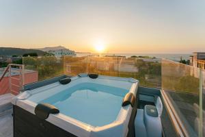 bañera de hidromasaje en el balcón con vistas al océano en Le Rondinelle Rooms en Procida