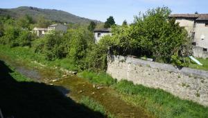 a stone retaining wall next to a river at River House in medieval bastide - Sleeps up to 6 in Chalabre