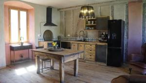 cocina con mesa de madera y nevera negra en River House in medieval bastide South of France, en Chalabre