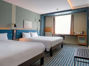 una camera d'albergo con due letti e una finestra di Novotel Luxembourg Kirchberg a Lussemburgo