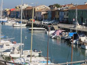 eine Gruppe von Booten, die in einem Yachthafen mit Gebäuden angedockt sind in der Unterkunft La Casetta del Porto in Pesaro